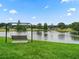 Scenic view of pond in community with swing on grassy bank at 1630 Se 29Th Ter, Ocala, FL 34471