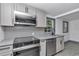 Modern kitchen with stainless steel appliances, tiled backsplash, and light grey cabinets at 1636 Sw 5Th Pl, Ocala, FL 34471