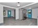 Open kitchen and living room with grey cabinets and stainless steel appliances plus turquoise door at 1636 Sw 5Th Pl, Ocala, FL 34471