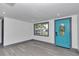 Bright living room with wood-look floors, white walls, and a bright blue front door at 1636 Sw 5Th Pl, Ocala, FL 34471