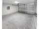 A spacious two car garage with a steel garage door, and concrete flooring at 1780 Winding Hills Rd, Dunnellon, FL 34431