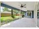A spacious covered back porch with ceiling fans, and view of a fenced yard with a grill at 1841 Ne 38Th St, Ocala, FL 34479
