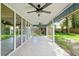 Long, screened-in back porch with a concrete floor, offering a view of the green backyard at 1841 Ne 38Th St, Ocala, FL 34479