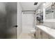 Bathroom featuring a tub and shower combination, neutral gray vanity, and convenient towel storage at 1841 Ne 38Th St, Ocala, FL 34479