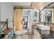 Cozy bathroom featuring a sliding barn door, stylish vanity, toilet, and patterned tile floor at 1841 Ne 38Th St, Ocala, FL 34479