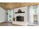 Living room boasts a charming fireplace with white brick surround, wood mantle, and lots of natural light at 1841 Ne 38Th St, Ocala, FL 34479