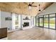 Bright living room with wood-look floors, beamed wood ceiling, fireplace, large windows, and backyard views at 1841 Ne 38Th St, Ocala, FL 34479