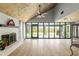 Bright living room features a brick fireplace, wood ceilings, and large windows overlooking the backyard at 1841 Ne 38Th St, Ocala, FL 34479