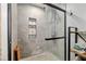 Modern shower with stone tile, glass door, mosaic tile accent, and multi-jet shower head at 1841 Ne 38Th St, Ocala, FL 34479