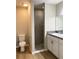 Bathroom featuring a walk-in shower with gray tiling, toilet, and modern vanity with a sink at 185 Malauka Loop, Ocklawaha, FL 32179