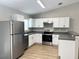 Modern kitchen featuring stainless steel appliances, white cabinetry, and durable counter tops at 185 Malauka Loop, Ocklawaha, FL 32179
