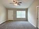 Inviting living room with neutral walls, carpet, a ceiling fan and natural light from a window at 185 Malauka Loop, Ocklawaha, FL 32179