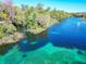 Stunning aerial view of the river, showcasing clear turquoise water surrounded by trees at 19424 Sw 77Th Loop, Dunnellon, FL 34432