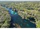 Expansive aerial view of a clear river meandering through a vibrant green landscape, highlighting the area's natural beauty at 19424 Sw 77Th Loop, Dunnellon, FL 34432