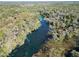 Scenic aerial shot of a winding river cutting through a dense forest, displaying a picturesque and tranquil environment at 19424 Sw 77Th Loop, Dunnellon, FL 34432