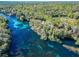 Breathtaking aerial view of a serene river flowing through lush green forest, showcasing a beautiful natural setting at 19424 Sw 77Th Loop, Dunnellon, FL 34432