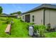 Landscaped backyard featuring green grass, garden beds, and a home exterior with a screened-in patio area at 19424 Sw 77Th Loop, Dunnellon, FL 34432