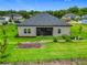 Spacious backyard with green lawn, garden area, and screened lanai, offering an ideal outdoor living space at 19424 Sw 77Th Loop, Dunnellon, FL 34432