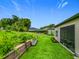 Beautiful backyard featuring a lush lawn, raised garden beds, and a screened lanai, perfect for outdoor living at 19424 Sw 77Th Loop, Dunnellon, FL 34432