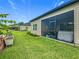 Beautiful backyard with a screened patio featuring a hot tub, lush green lawn, and well-maintained landscaping at 19424 Sw 77Th Loop, Dunnellon, FL 34432