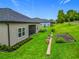 Well-maintained backyard with lush green grass, raised garden beds, and a screened-in patio for outdoor enjoyment at 19424 Sw 77Th Loop, Dunnellon, FL 34432