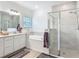 Bathroom featuring a soaking tub, glass-enclosed shower, and modern fixtures at 19424 Sw 77Th Loop, Dunnellon, FL 34432