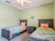 Comfortable bedroom with two twin beds, ceiling fan and carpet flooring at 19424 Sw 77Th Loop, Dunnellon, FL 34432