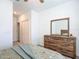 Bright bedroom featuring a wooden dresser, mirror and carpeted floors at 19424 Sw 77Th Loop, Dunnellon, FL 34432