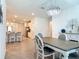 Bright dining room with a stylish chandelier and wood-look tile flooring open to kitchen at 19424 Sw 77Th Loop, Dunnellon, FL 34432