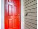 Stylish red front door with modern hardware and a Ring doorbell, set against neutral siding at 19424 Sw 77Th Loop, Dunnellon, FL 34432