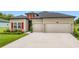 Beautiful home with a manicured lawn, red shutters, and convenient two-car garage at 19424 Sw 77Th Loop, Dunnellon, FL 34432
