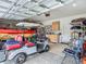 Spacious garage featuring golf cart, storage racks, and a workbench area for organized utility and recreational space at 19424 Sw 77Th Loop, Dunnellon, FL 34432