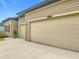Spacious two-car garage with a driveway, and tan siding, offering ample parking and storage at 19424 Sw 77Th Loop, Dunnellon, FL 34432