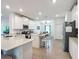 Open-concept kitchen boasts white cabinetry, quartz countertops, and stainless steel appliances at 19424 Sw 77Th Loop, Dunnellon, FL 34432