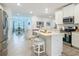 Open kitchen layout features white cabinetry, stone countertops, and an island with stool seating at 19424 Sw 77Th Loop, Dunnellon, FL 34432