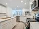 Bright kitchen with island, stainless appliances, white cabinets and dining nook with chandelier at 19424 Sw 77Th Loop, Dunnellon, FL 34432