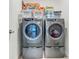 Modern laundry room features gray Electrolux front load washer and dryer with white storage baskets on the top shelf at 19424 Sw 77Th Loop, Dunnellon, FL 34432
