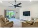 Spacious living room with large ceiling fan and a sliding glass door that leads to the patio at 19424 Sw 77Th Loop, Dunnellon, FL 34432