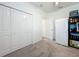 Well-lit pantry with a fridge, shelving, carpet flooring, and closet doors at 19424 Sw 77Th Loop, Dunnellon, FL 34432