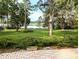 Expansive backyard featuring mature trees, a well-maintained lawn, and a serene lake view at 2131 Ne 145Th Avenue Rd, Silver Springs, FL 34488