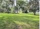 Expansive green lawn extends to the water's edge, framed by mature trees and lush greenery at 2131 Ne 145Th Avenue Rd, Silver Springs, FL 34488