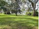 Lush backyard with mature trees overlooking a tranquil lake, ideal for relaxation at 2131 Ne 145Th Avenue Rd, Silver Springs, FL 34488
