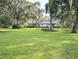Spacious front yard showcasing a well-maintained lawn, mature trees, and a single-story home at 2131 Ne 145Th Avenue Rd, Silver Springs, FL 34488