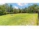 Vast grassy backyard, enclosed by a wooden fence, offering privacy and space at 2151 Se 59Th St, Ocala, FL 34480