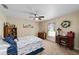 Comfortable bedroom with a striped bedspread, desk, and a bright, sunny window at 2151 Se 59Th St, Ocala, FL 34480