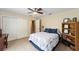 A cozy bedroom with a ceiling fan, closet, and bookshelf at 2151 Se 59Th St, Ocala, FL 34480