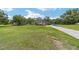Wide angle of a house exterior surrounded by a green lawn and trees under a blue sky with some clouds at 2151 Se 59Th St, Ocala, FL 34480
