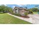 Charming home exterior featuring stone accents, manicured landscaping, and a well-maintained lawn at 2151 Se 59Th St, Ocala, FL 34480