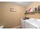 A functional laundry room with modern appliances, convenient shelving, and tiled flooring at 2151 Se 59Th St, Ocala, FL 34480
