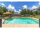 Backyard pool surrounded by a black fence and mature trees offering a private oasis at 2151 Se 59Th St, Ocala, FL 34480